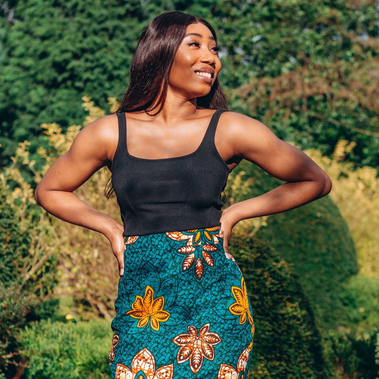 Orange, yellow, white and green African print High Waisted knee length Flared fishtail Skirt with seamed belt detailing in a floral pattern, made from sustainably sourced Ankara wax print.