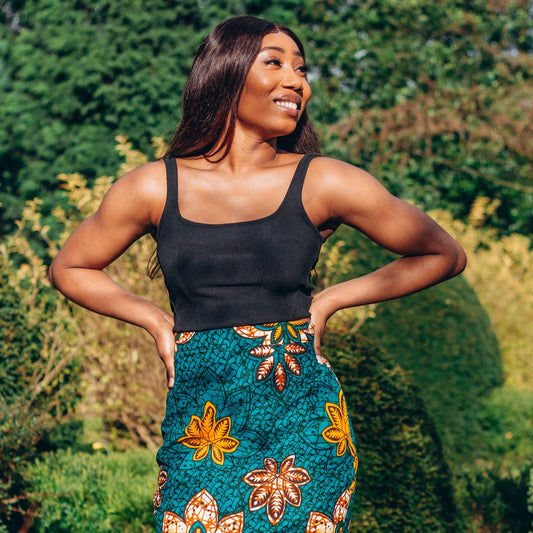 Orange, yellow, white and green African print High Waisted knee length Flared fishtail Skirt with seamed belt detailing in a floral pattern, made from sustainably sourced Ankara wax print.
