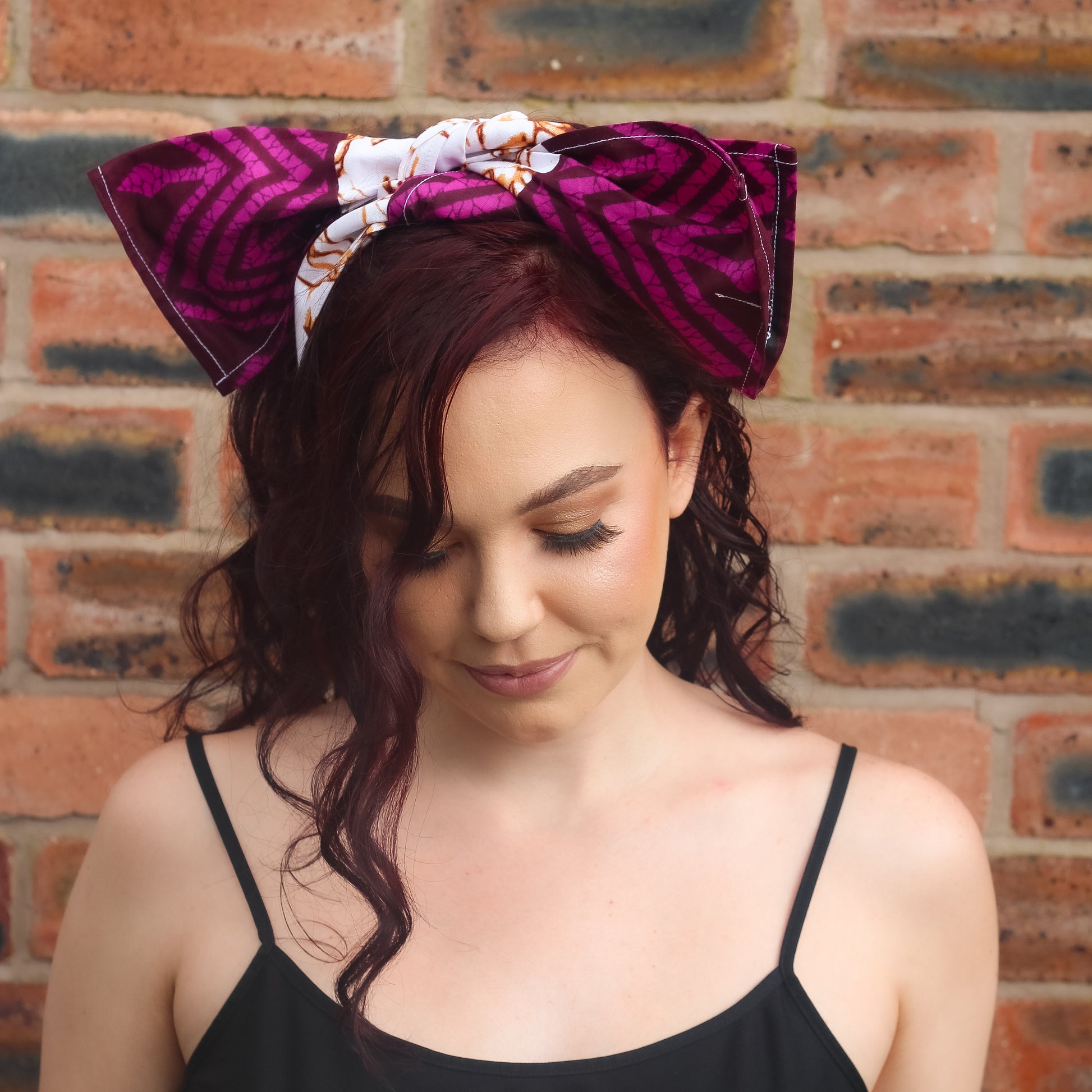 Purple, brown, and white African print head wrap tied as headband in a granite pattern, made from sustainably sourced Ankara wax print. 