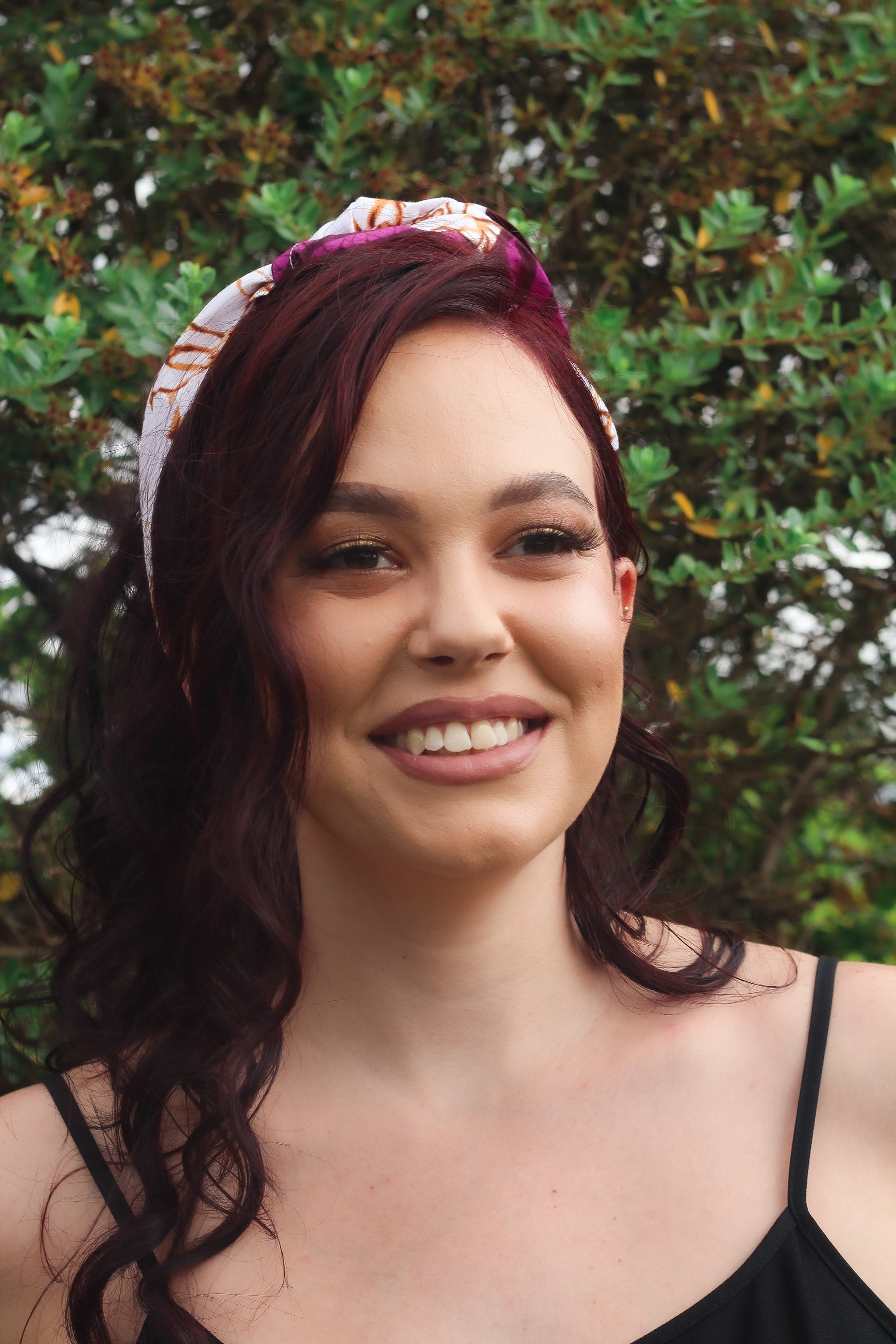 Purple, brown, and white African print head wrap tied as headband in a granite pattern, made from sustainably sourced Ankara wax print. 