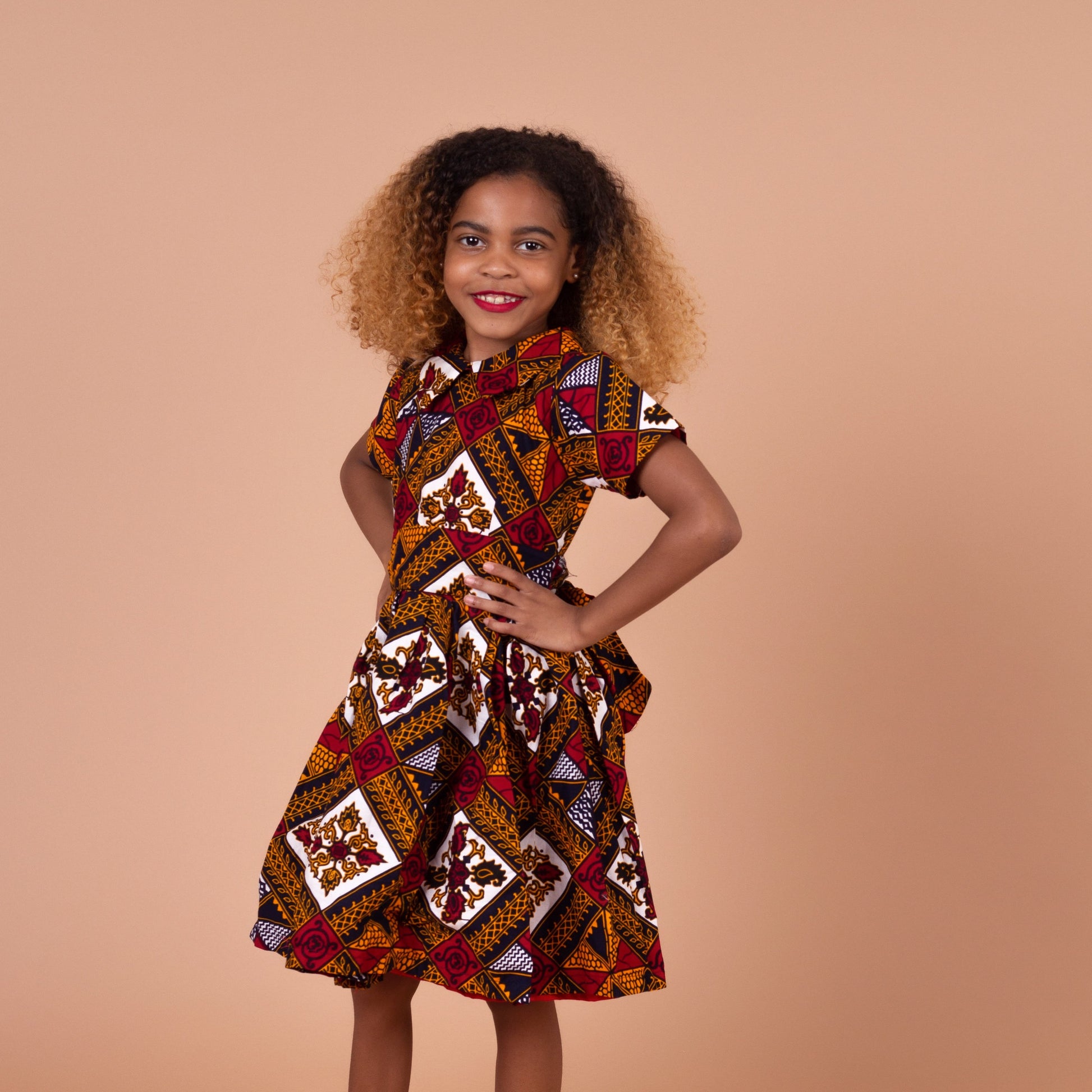  Ankara wax printed Knee length flared belted  dress with short sleeves and collared neckline in Red, yellow, white and black Squared African medallion pattern.