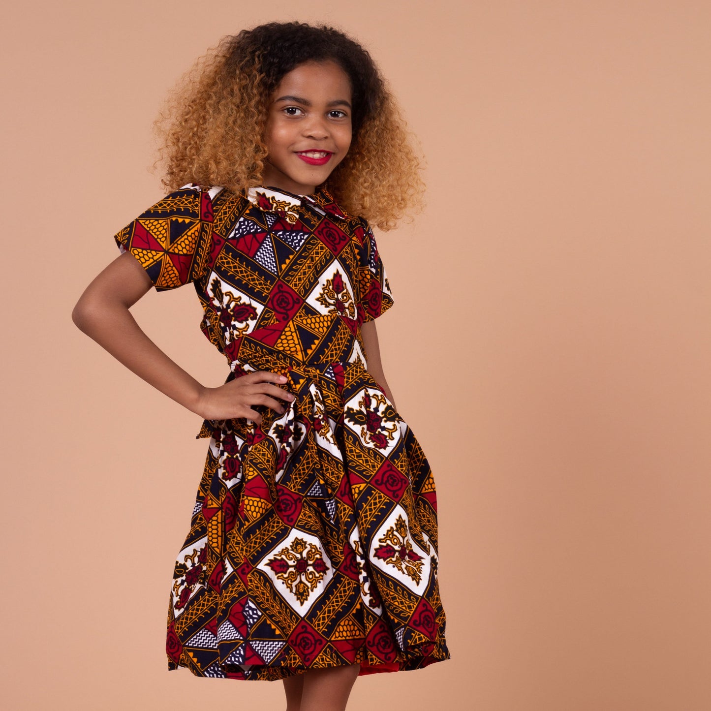  Ankara wax printed Knee length flared belted  dress with short sleeves and collared neckline in Red, yellow, white and black Squared African medallion pattern.