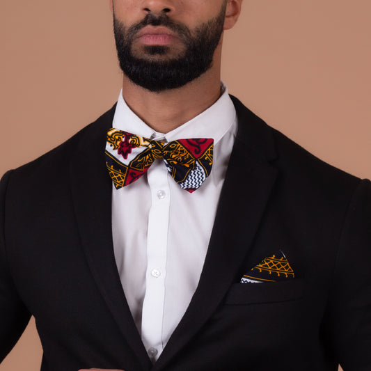Man wearing Red, white, navy blue and yellow pocket square and bow tie with a black blazer and a white shirt