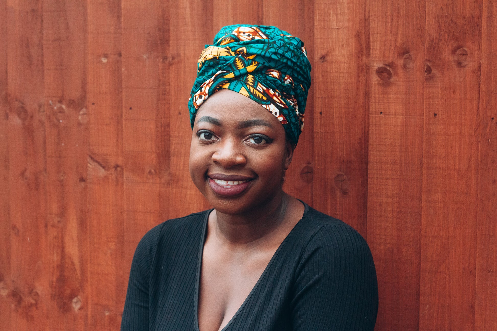 Orange, yellow, white and green African print head wrap tied a turban in a floral pattern, made from sustainably sourced Ankara wax print. 