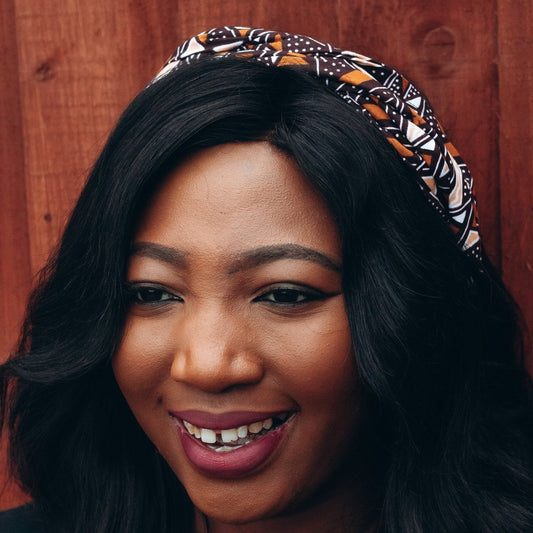 Brown, black and white African print head wrap tied a headband in graphic triangle pattern, made from sustainably sourced Ankara wax print. 