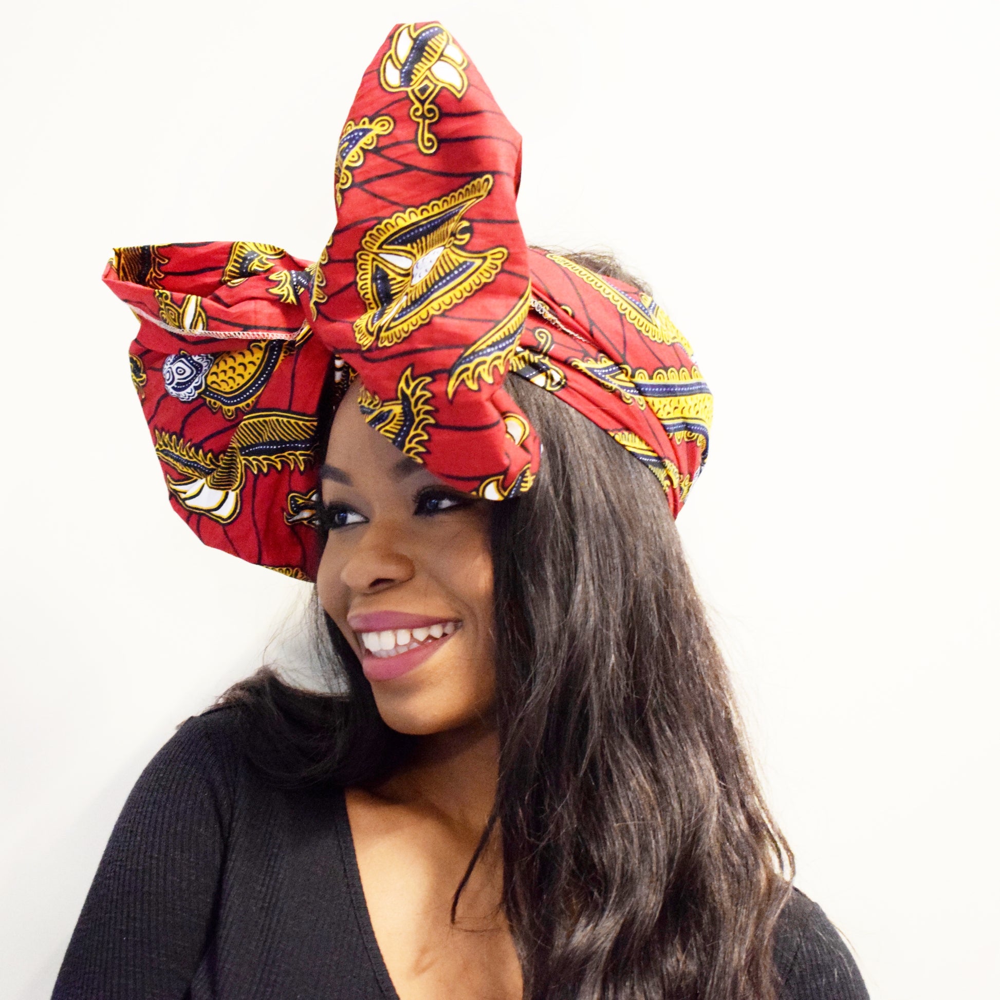 Red, yellow white and black African print head wrap tied as headband in a floral medallion pattern, made from sustainably sourced Ankara wax print.