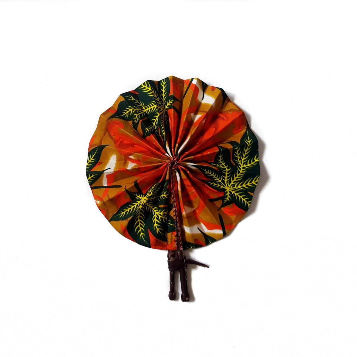  African print fan made from ankara wax print in an orange, yellow and black autumnal leaf pattern finished with dark brown leather clasp