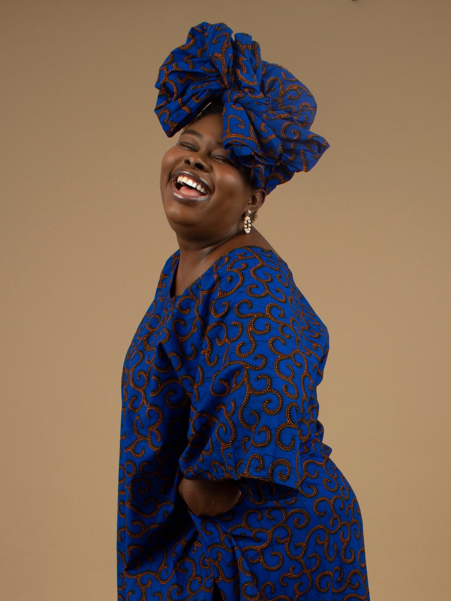 The Ore Floor Length lightweight African Print Kaftan Dress in Ankara wax print in a deep blue and orange swirling African Print pattern is ethically sourced cotton. Designed in England Made in Nigeria. 