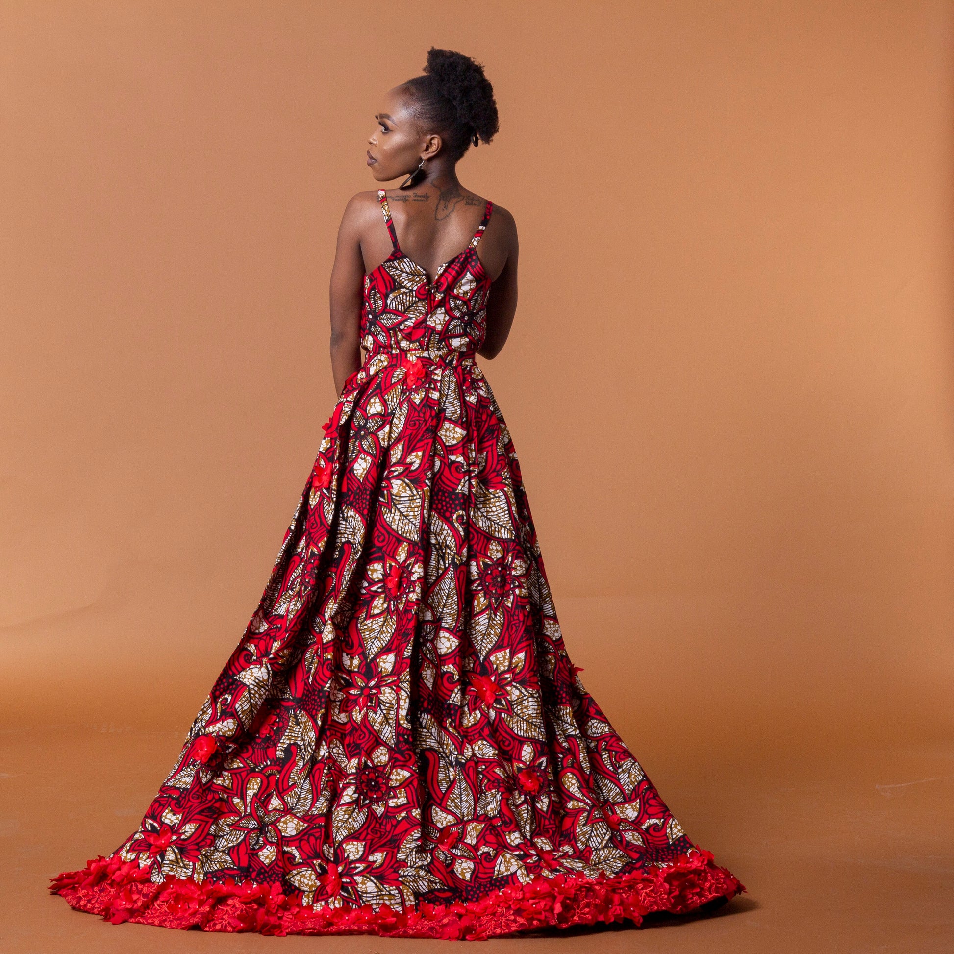 Side view of red african print cape in floral ankara wax print fastened at the waist