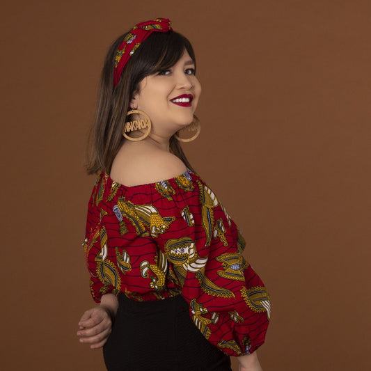Red, yellow white and black African print head wrap tied as headband in a floral medallion pattern, made from sustainably sourced Ankara wax print.