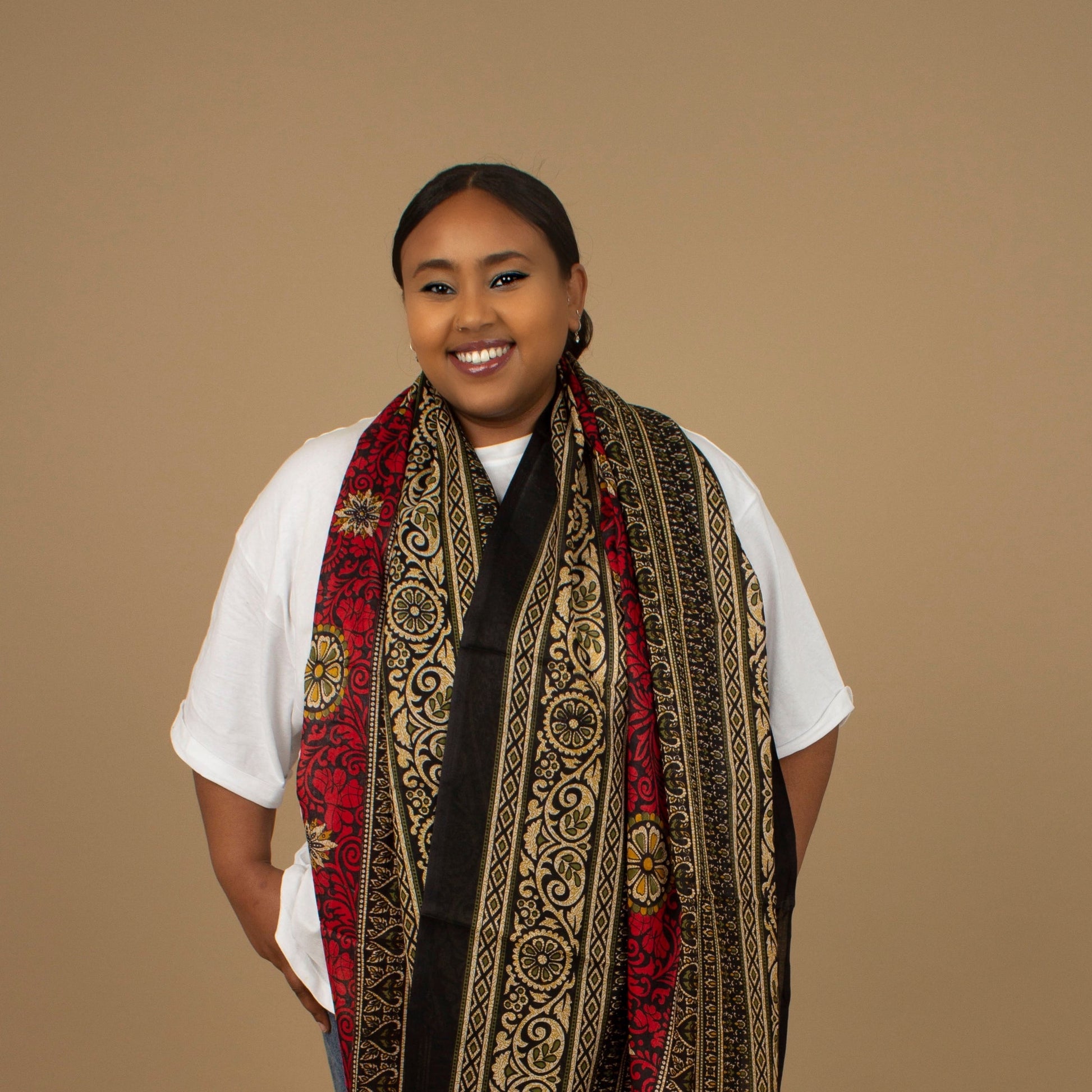 The one-sized Red Dashiki Chiffon Scarf is a vibrant floral African Print in an extremely flattering, red, gold and black African floral dashiki Print pattern. The Red Dashiki Chiffon Scarf is printed on a luxurious Chiffon that is ethically sourced, Designed in England Made in Nigeria. 