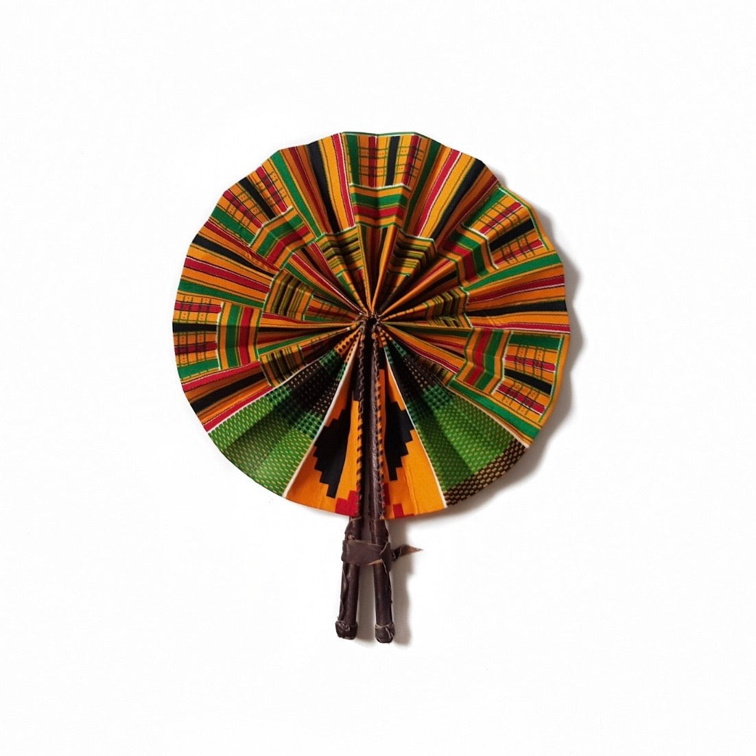 Multicoloured African print fan made from green, yellow, red and black kente wax print and finished with a dark brown leather clasp