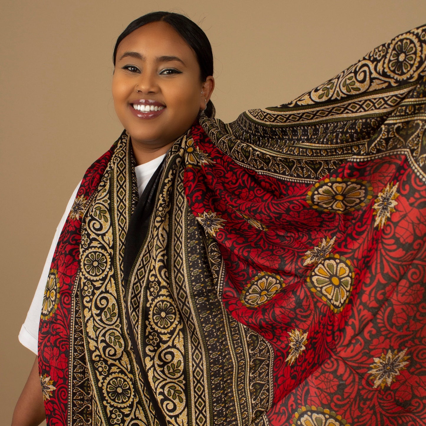 The one-sized Red Dashiki Chiffon Scarf is a vibrant floral African Print in an extremely flattering, red, gold and black African floral dashiki Print pattern. The Red Dashiki Chiffon Scarf is printed on a luxurious Chiffon that is ethically sourced, Designed in England Made in Nigeria. 