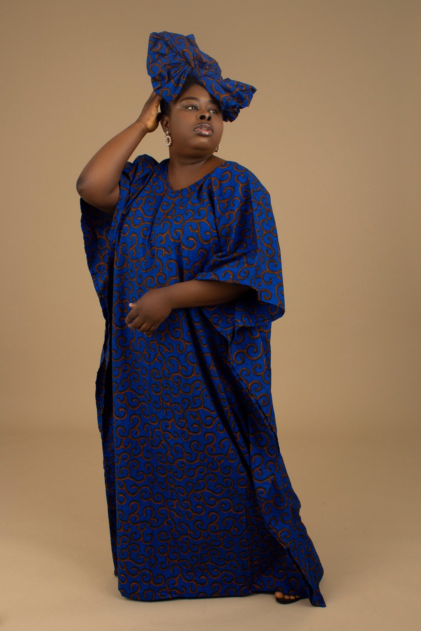 The Ore Floor Length lightweight African Print Kaftan Dress in Ankara wax print in a deep blue and orange swirling African Print pattern is ethically sourced cotton. Designed in England Made in Nigeria. 