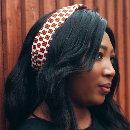 Brown, orange and white African print head wrap tied as headband in a titled squared brick pattern, made from sustainably sourced Ankara wax print.