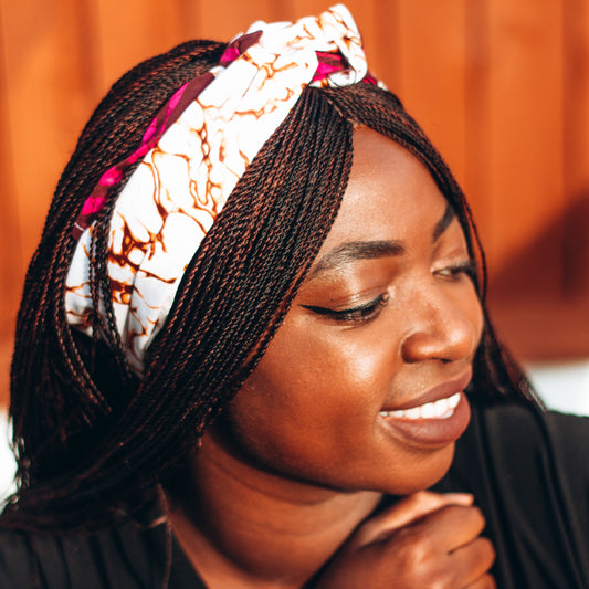 Purple, brown, and white African print head wrap tied as headband in a granite pattern, made from sustainably sourced Ankara wax print. 