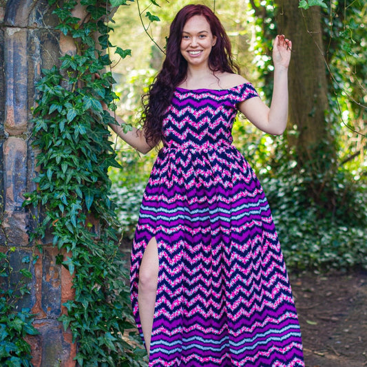  Purple and black African zig-zag texture over-laying a lilac, blue and whites spotted-mesh Ankara wax print on a floor length, short off the shoulder sleeved skater skirt, maxi dress with a thigh high slit.
