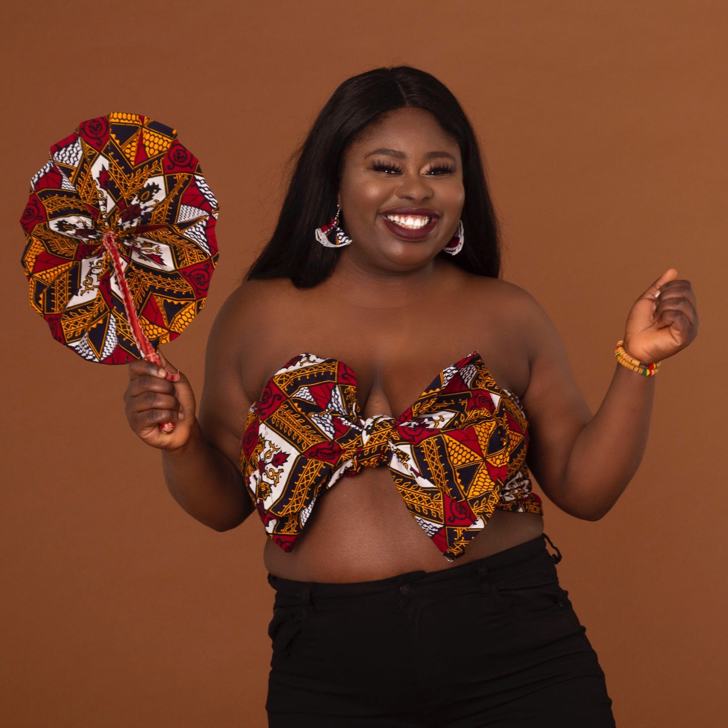 red, yellow, white, and black African print head wrap tied as an accessory in floral medallion pattern, made from sustainably sourced Ankara wax print.