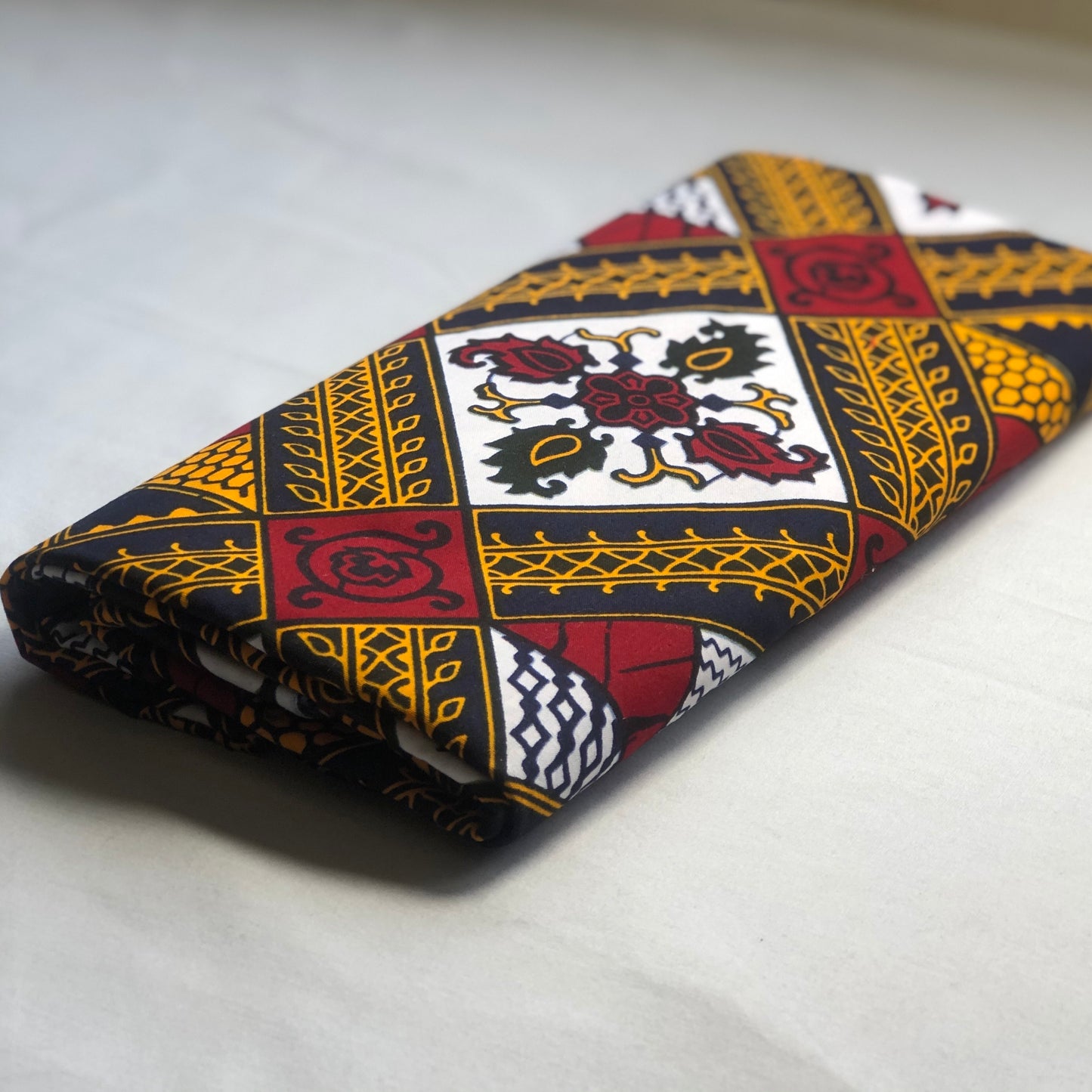 red, yellow, white, and black African print head wrap fabric in floral medallion pattern, made from sustainably sourced Ankara wax print.