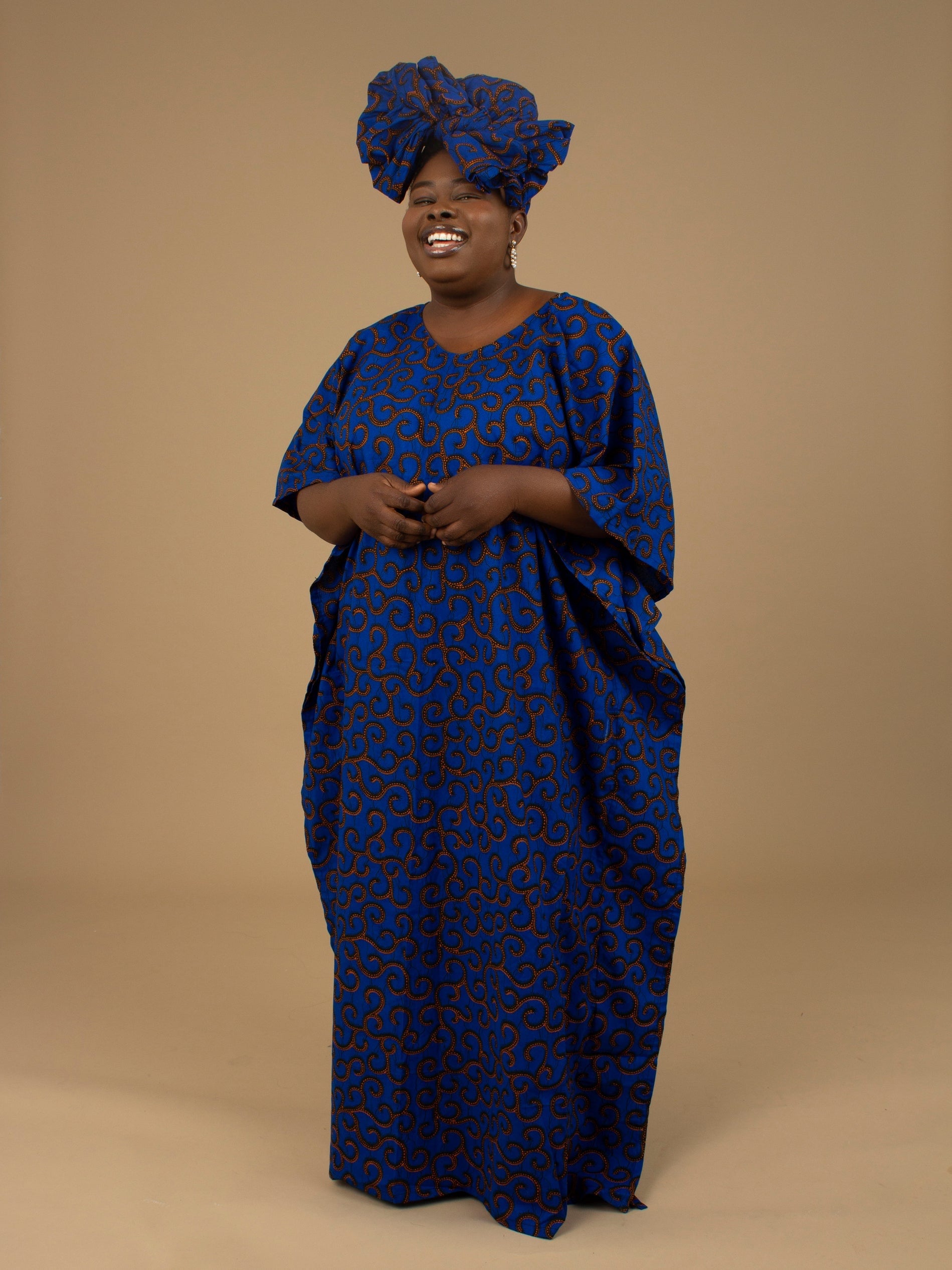 The Ore Floor Length lightweight African Print Kaftan Dress in Ankara wax print in a deep blue and orange swirling African Print pattern is ethically sourced cotton. Designed in England Made in Nigeria. 