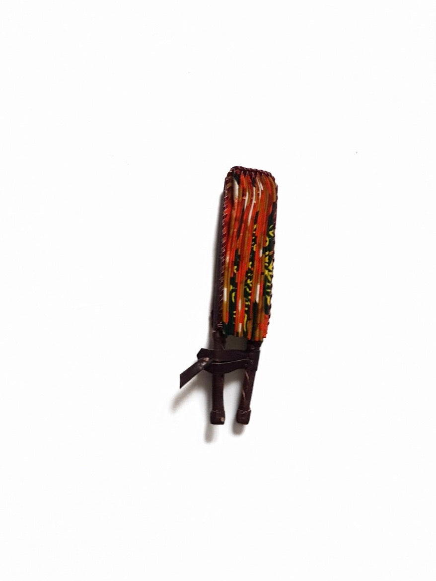  African print fan made from ankara wax print in an orange, yellow and black autumnal leaf pattern finished with dark brown leather clasp