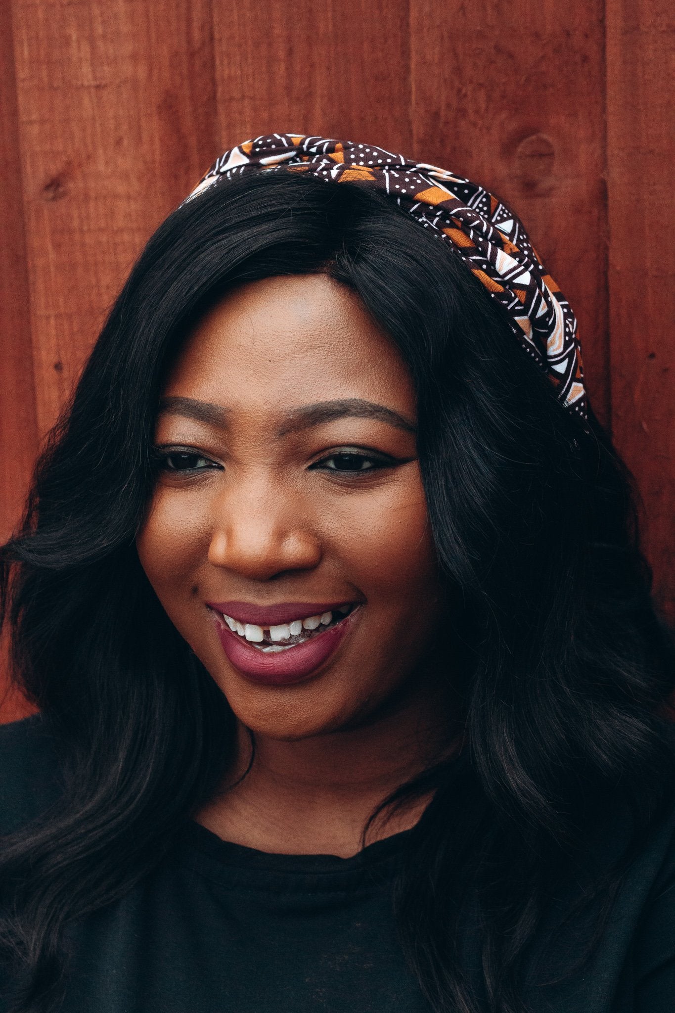 Brown, black and white African print head wrap tied a headband in graphic triangle pattern, made from sustainably sourced Ankara wax print. 