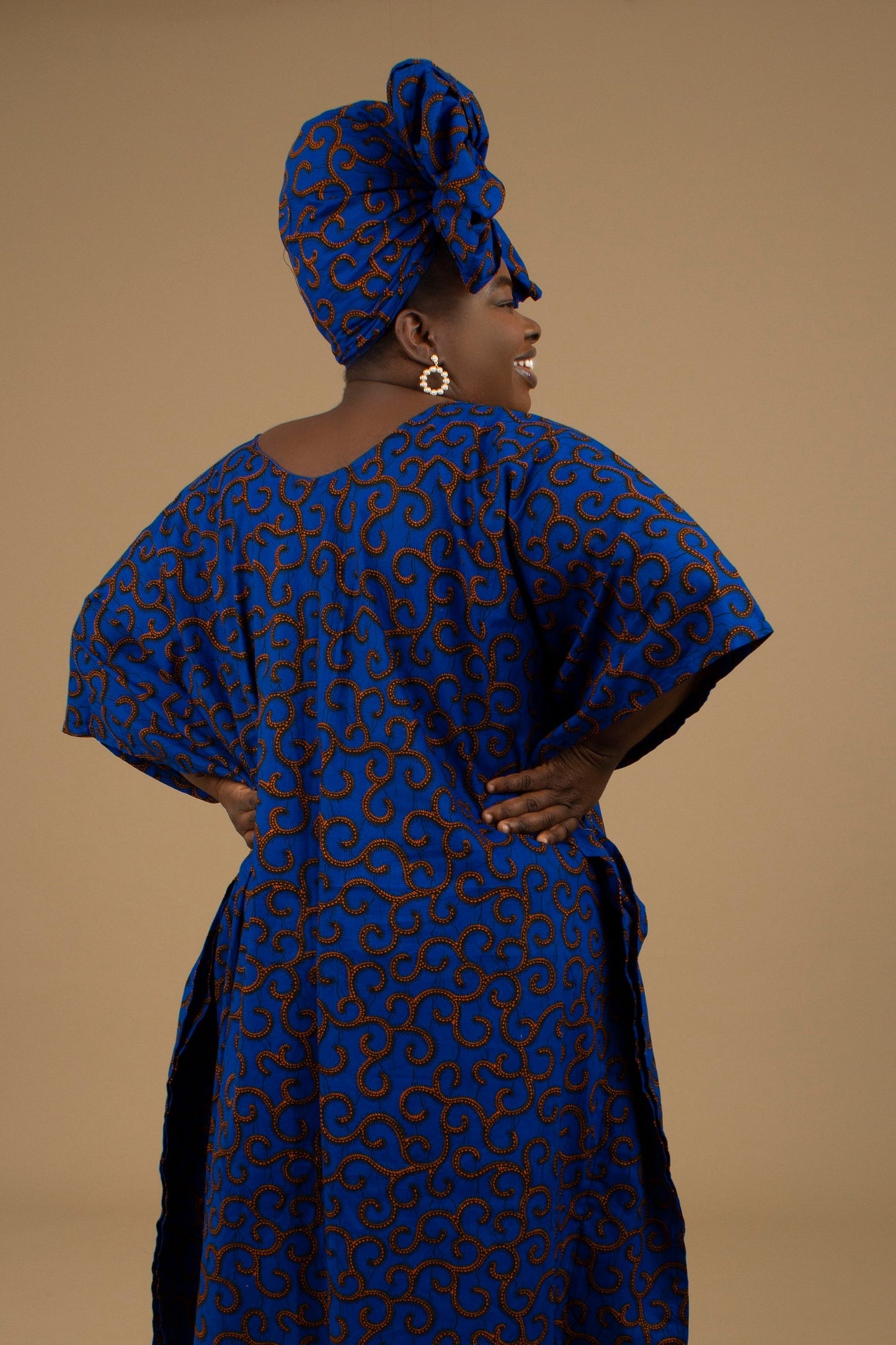 The Ore Floor Length lightweight African Print Kaftan Dress in Ankara wax print in a deep blue and orange swirling African Print pattern is ethically sourced cotton. Designed in England Made in Nigeria. 