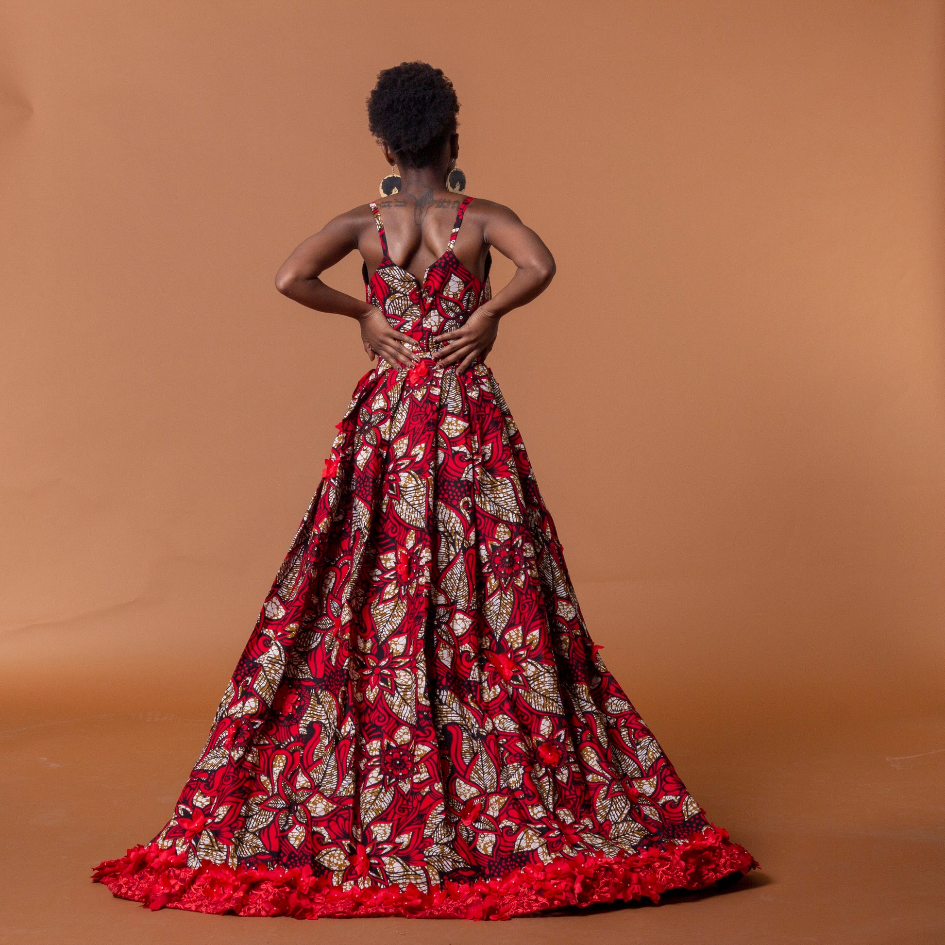 Back view of red african print cape in floral ankara wax print fastened at the waist