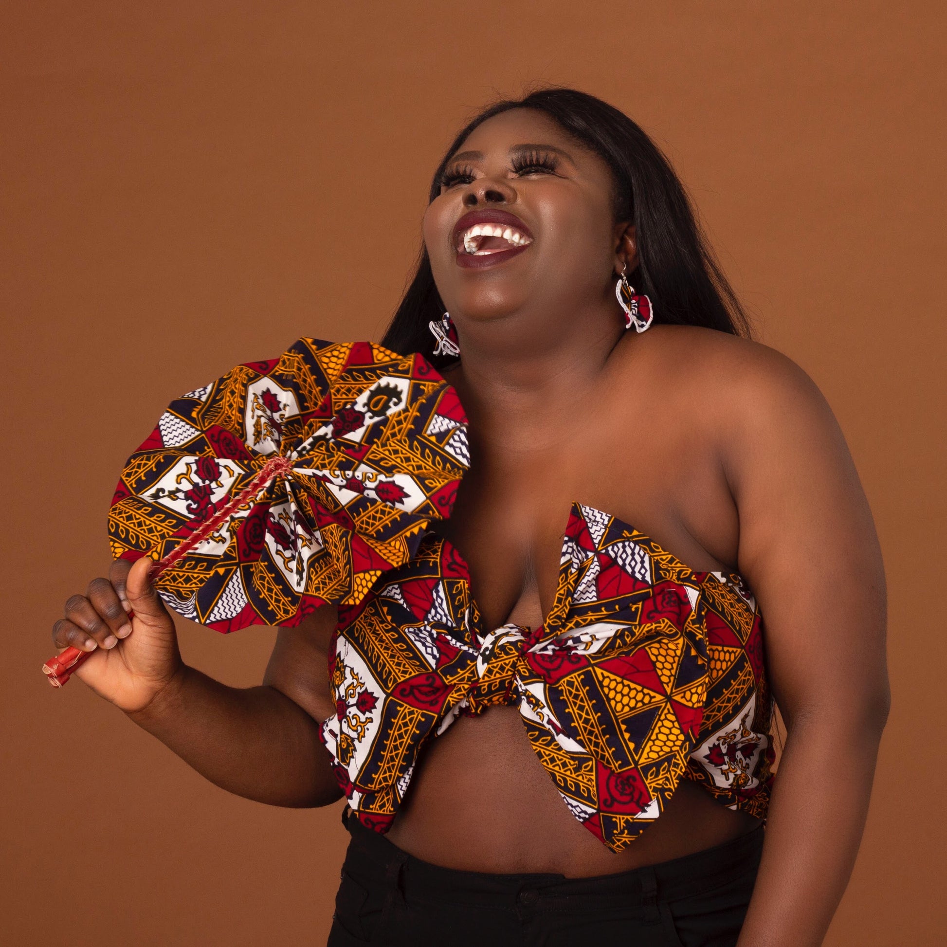 red, yellow, white, and black African print head wrap tied as an accessory in floral medallion pattern, made from sustainably sourced Ankara wax print.