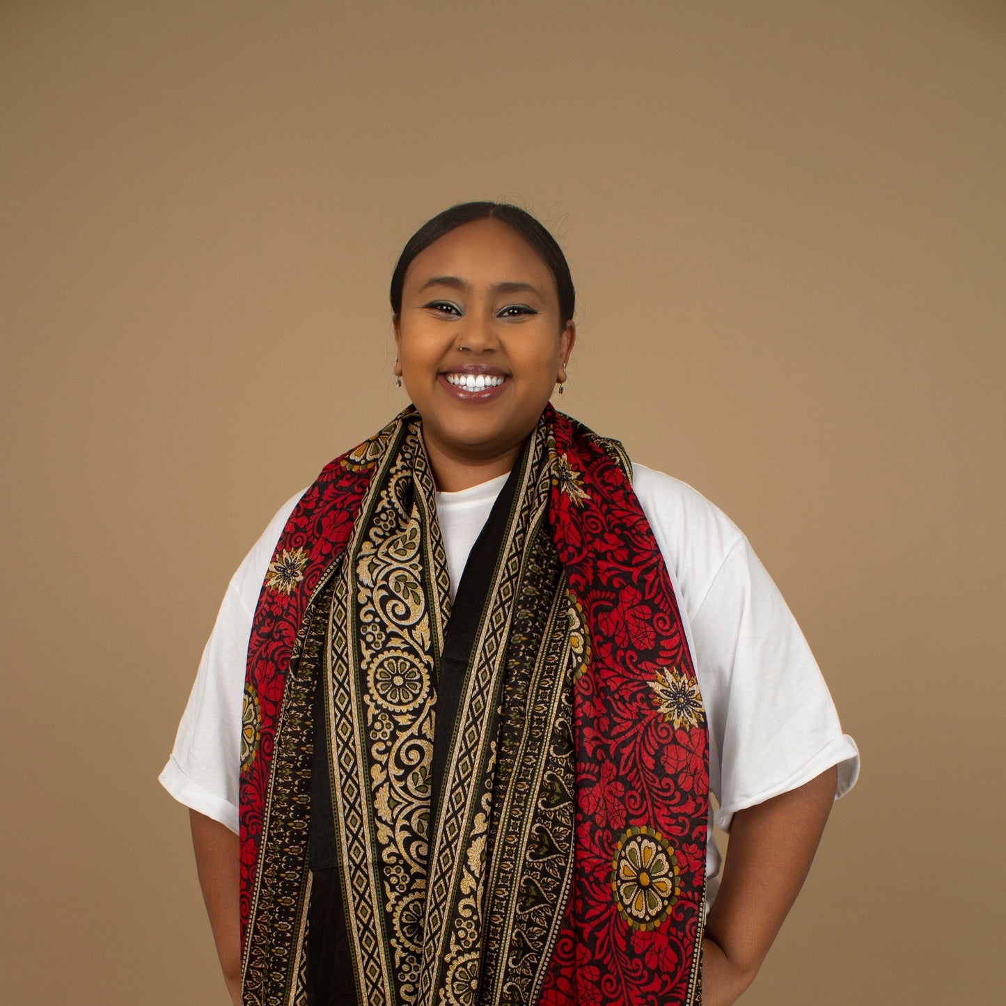 The one-sized Red Dashiki Chiffon Scarf is a vibrant floral African Print in an extremely flattering, red, gold and black African floral dashiki Print pattern. The Red Dashiki Chiffon Scarf is printed on a luxurious Chiffon that is ethically sourced, Designed in England Made in Nigeria. 